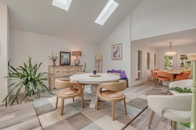 11198 S Wyngate Ln E, Sandy, UT 84092 - dining space with light wood-style flooring, a skylight, high vaulted ceiling, a chandelier, and baseboards