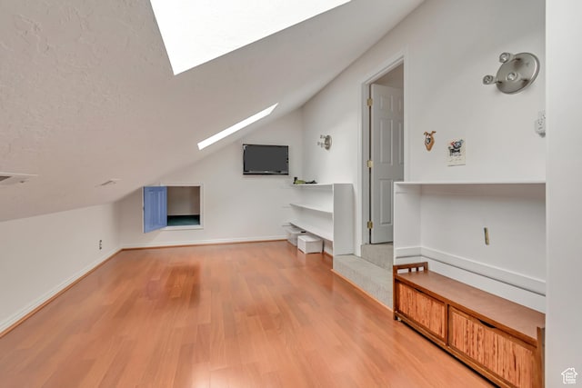 11198 S Wyngate Ln E, Sandy, UT 84092 - additional living space featuring a skylight, vaulted ceiling, wood finished floors, baseboards, and a textured ceiling