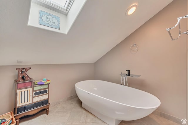 11198 S Wyngate Ln E, Sandy, UT 84092 - bathroom with a soaking tub, a skylight, baseboards, vaulted ceiling, and tile patterned floors