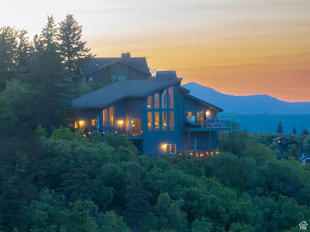 7340 Buckboard Dr N, Park City, UT 84098 - back of house with a balcony, a mountain view, and a chimney