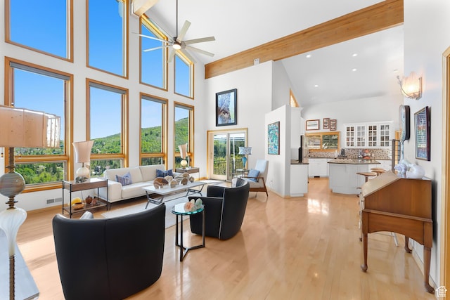 7340 Buckboard Dr N, Park City, UT 84098 - living room with high vaulted ceiling, plenty of natural light, beamed ceiling, a ceiling fan, and light wood-type flooring