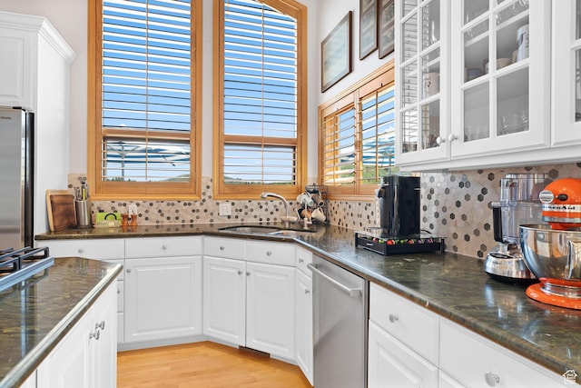7340 Buckboard Dr N, Park City, UT 84098 - kitchen with stainless steel appliances, a sink, tasteful backsplash, glass insert cabinets, and white cabinets