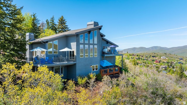 7340 Buckboard Dr N, Park City, UT 84098 - rear view of house featuring a chimney, a balcony, and a deck with mountain view