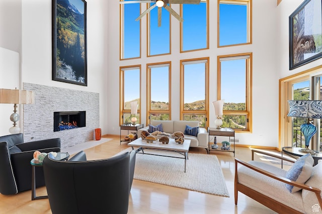 7340 Buckboard Dr N, Park City, UT 84098 - living area featuring a towering ceiling, a warm lit fireplace, baseboards, and wood finished floors