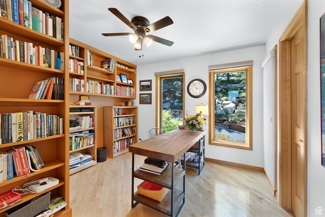 7340 Buckboard Dr N, Park City, UT 84098 - office space with light wood-type flooring, ceiling fan, wall of books, and baseboards