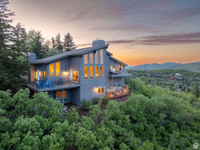 7340 Buckboard Dr N, Park City, UT 84098 - back of house at dusk with a chimney, a balcony, and a mountain view