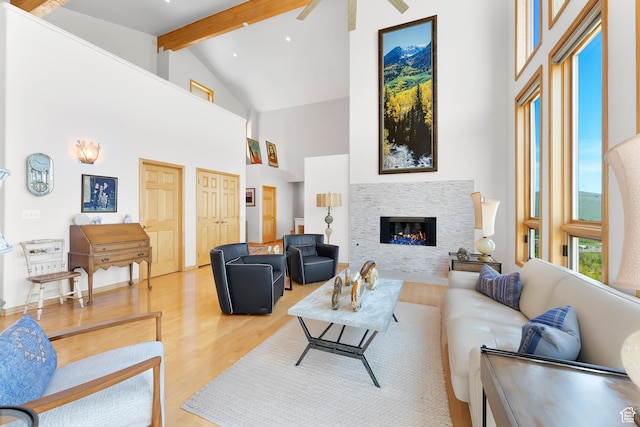 7340 Buckboard Dr N, Park City, UT 84098 - living area with high vaulted ceiling, light wood-style flooring, beam ceiling, a glass covered fireplace, and ceiling fan
