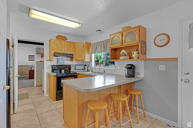 3966 W 2200 N, Plain City, UT 84404 - kitchen with black range with electric stovetop, under cabinet range hood, a sink, stainless steel microwave, and a peninsula