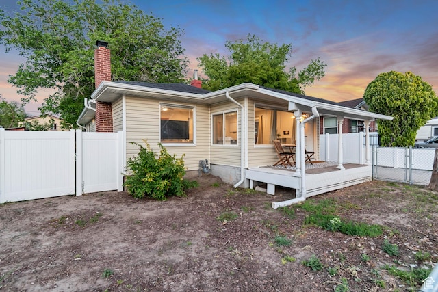 2867 S Cyprus Ln, Magna, UT 84044 - view of front of house with a chimney, a wooden deck, and a gate