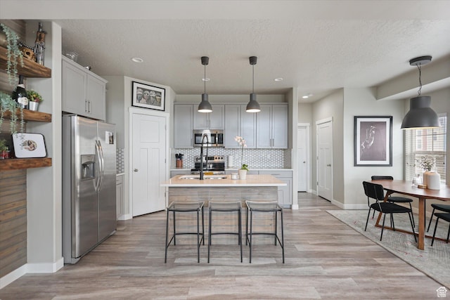 702 E 330 N, Vineyard, UT 84059 - kitchen with stainless steel appliances, baseboards, light countertops, backsplash, and a textured ceiling
