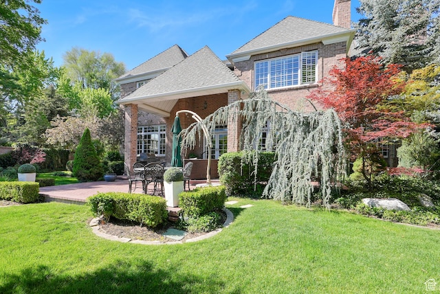 2051 E Normandywoods Ct, Holladay, UT 84117 - view of front of home featuring a chimney, a front yard, brick siding, and a patio area