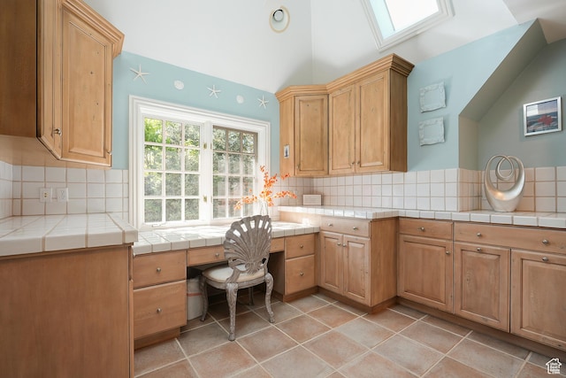 2051 E Normandywoods Ct, Holladay, UT 84117 - kitchen featuring decorative backsplash, tile countertops, vaulted ceiling, and a skylight