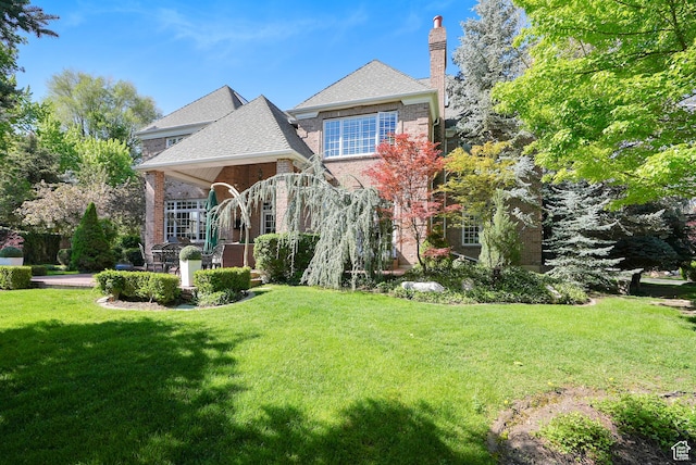2051 E Normandywoods Ct, Holladay, UT 84117 - rear view of house featuring a lawn, brick siding, a chimney, and a shingled roof