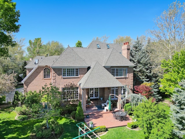 2051 E Normandywoods Ct, Holladay, UT 84117 - back of property with a chimney, a patio area, a lawn, and brick siding