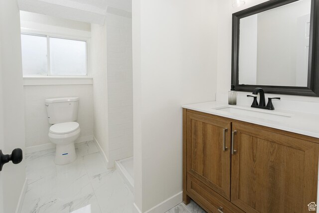2213 Ogden Ave, Ogden, UT 84401 - bathroom with baseboards, marble finish flooring, toilet, and vanity