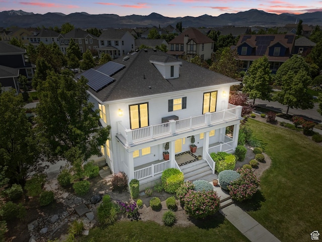 10416 S Vermillion Dr W, South Jordan, UT 84009 - view of front of property with a balcony, a mountain view, covered porch, roof with shingles, and a front lawn