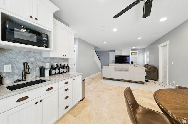 10416 S Vermillion Dr W, South Jordan, UT 84009 - kitchen featuring a sink, black microwave, ceiling fan, white cabinetry, and decorative backsplash