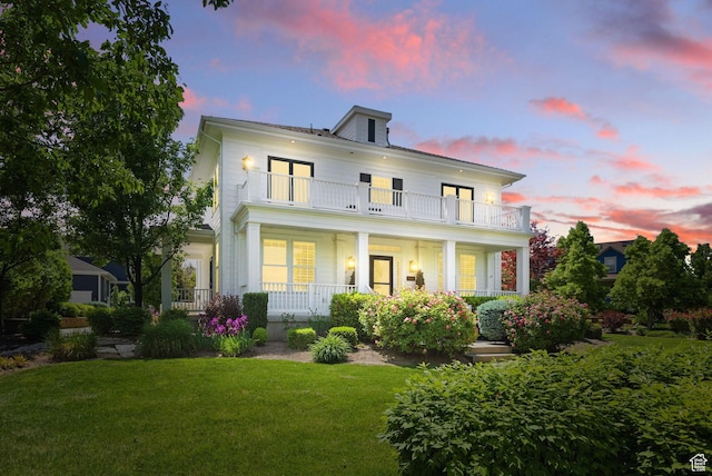 10416 S Vermillion Dr W, South Jordan, UT 84009 - back of property at dusk featuring a balcony, covered porch, and a lawn