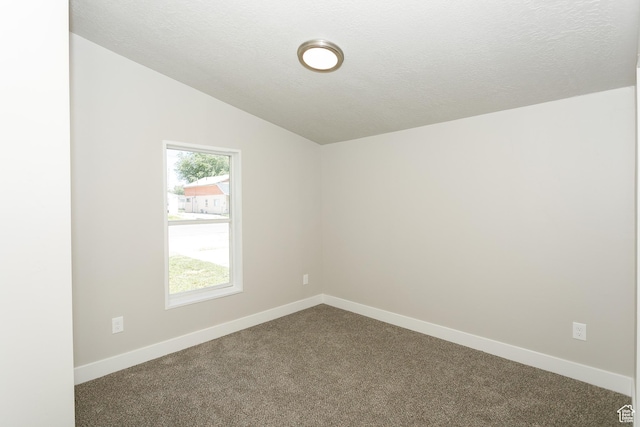 1623 W Claybourne Ave S, West Valley City, UT 84119 - spare room featuring vaulted ceiling, dark carpet, baseboards, and a textured ceiling