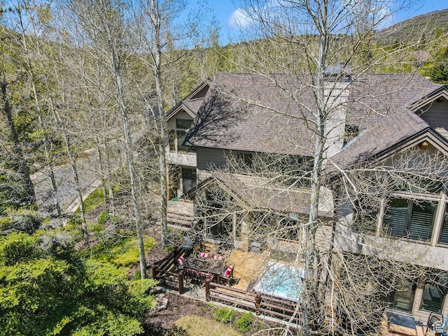 2464 Deer Lake Dr, Park City, UT 84060 - view of home's exterior featuring a chimney, a shingled roof, a patio, and a swimming pool