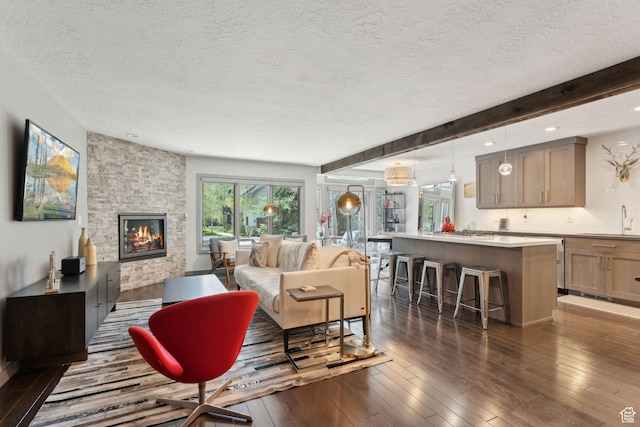 2464 Deer Lake Dr, Park City, UT 84060 - living area with a textured ceiling, a stone fireplace, dark wood-type flooring, recessed lighting, and beam ceiling