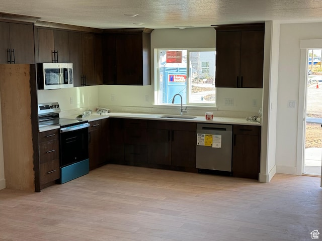 160 S 50 W, Clearfield, UT 84015 - kitchen with appliances with stainless steel finishes, a sink, light countertops, dark brown cabinetry, and light wood-style floors