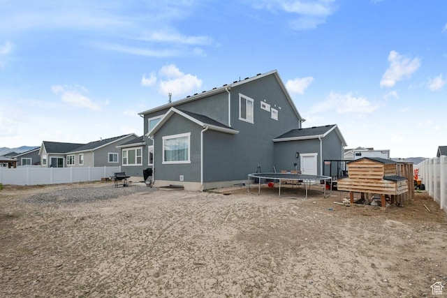 2076 E Granite Ln N Unit 145, Eagle Mountain, UT 84005 - back of property with a trampoline, a fenced backyard, and stucco siding