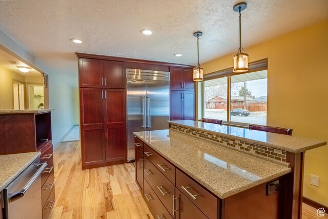 2215 W 800 N, West Point, UT 84015 - kitchen featuring appliances with stainless steel finishes, light wood finished floors, a center island, a textured ceiling, and hanging light fixtures