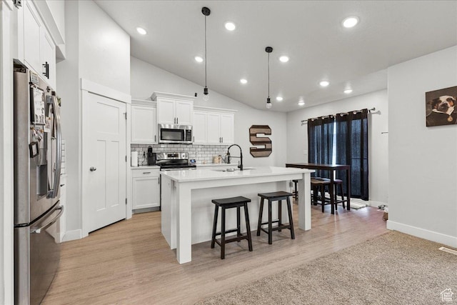 464 S Trejo Ridge Rd, Grantsville, UT 84029 - kitchen featuring appliances with stainless steel finishes, a sink, a breakfast bar, white cabinets, and baseboards