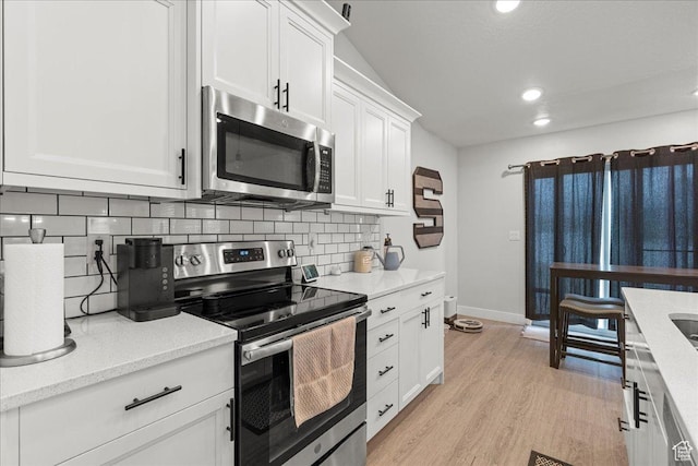464 S Trejo Ridge Rd, Grantsville, UT 84029 - kitchen featuring appliances with stainless steel finishes, tasteful backsplash, white cabinets, recessed lighting, and light wood-style flooring