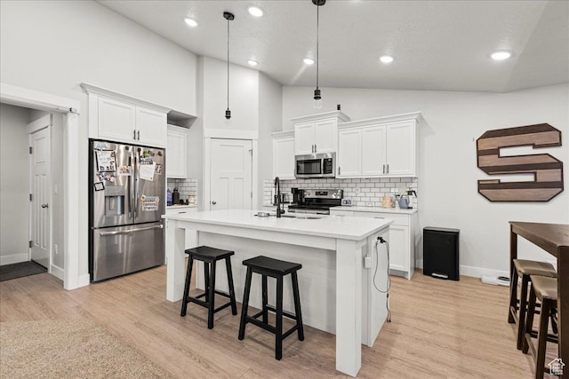 464 S Trejo Ridge Rd, Grantsville, UT 84029 - kitchen featuring stainless steel appliances, vaulted ceiling, light countertops, tasteful backsplash, and white cabinetry