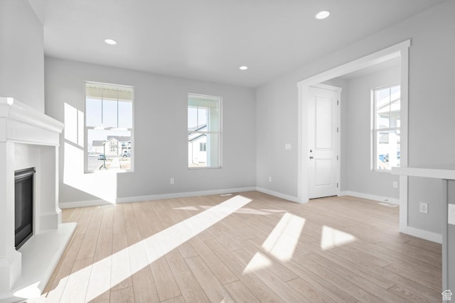 9806 N Willowbank Dr, Highland, UT 84003 - unfurnished living room featuring wood finished floors, a glass covered fireplace, baseboards, and recessed lighting