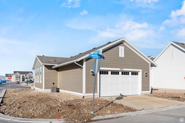 9806 N Willowbank Dr, Highland, UT 84003 - view of side of home featuring concrete driveway, a garage, and central AC unit