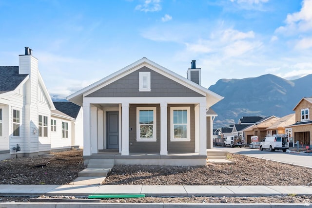 9806 N Willowbank Dr, Highland, UT 84003 - view of front of house featuring a porch, a chimney, and a mountain view
