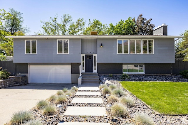 7282 S 2700 E, Salt Lake City, UT 84121 - split foyer home with a garage, a chimney, concrete driveway, and brick siding