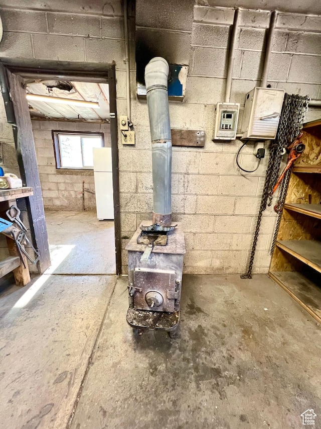 509 E 300 N, Richfield, UT 84701 - below grade area featuring freestanding refrigerator, a wood stove, and concrete block wall