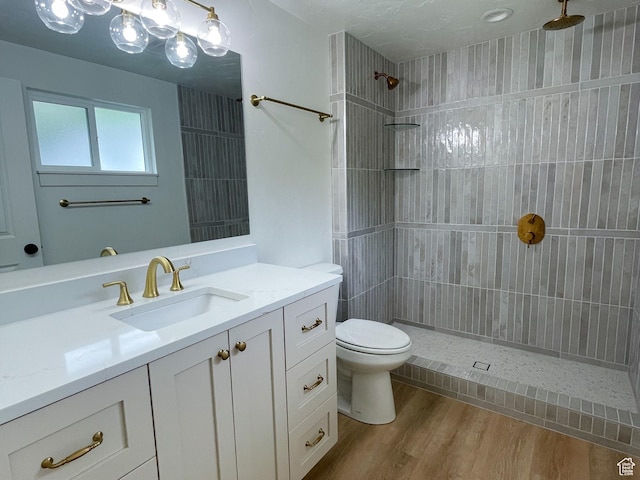 685 S Idaho Ave E, Provo, UT 84606 - bathroom with toilet, vanity, a tile shower, and wood finished floors