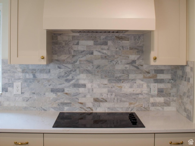 685 S Idaho Ave E, Provo, UT 84606 - kitchen view of exhaust hood, black electric stovetop, light countertops, and tasteful backsplash