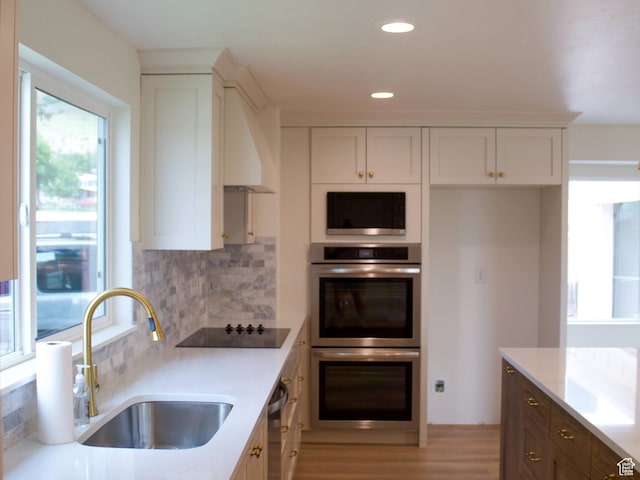 685 S Idaho Ave E, Provo, UT 84606 - kitchen with appliances with stainless steel finishes, a sink, tasteful backsplash, white cabinetry, and light wood-style floors