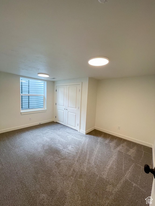 685 S Idaho Ave E, Provo, UT 84606 - unfurnished bedroom with dark carpet, baseboards, and a closet
