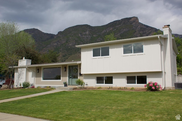685 S Idaho Ave E, Provo, UT 84606 - split level home featuring a chimney, a mountain view, a front lawn, and board and batten siding