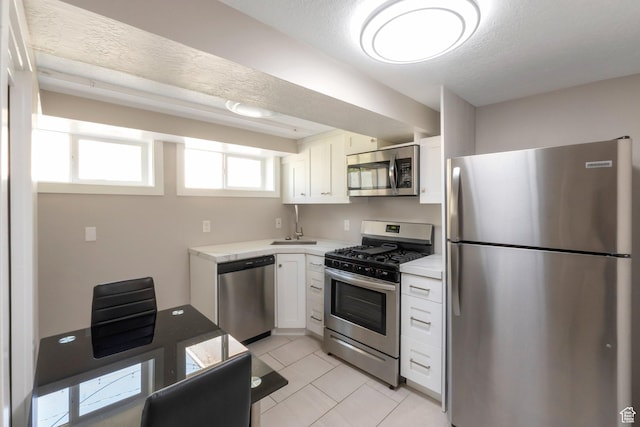 561 N 700 E, Provo, UT 84606 - kitchen with stainless steel appliances, light countertops, white cabinets, a sink, and light tile patterned flooring