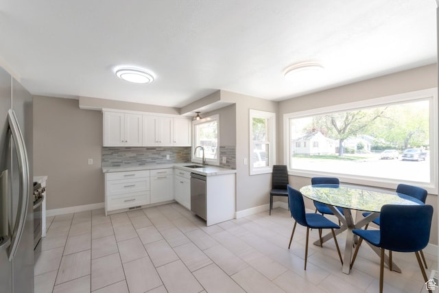 561 N 700 E, Provo, UT 84606 - kitchen featuring stainless steel appliances, light countertops, tasteful backsplash, a sink, and white cabinets