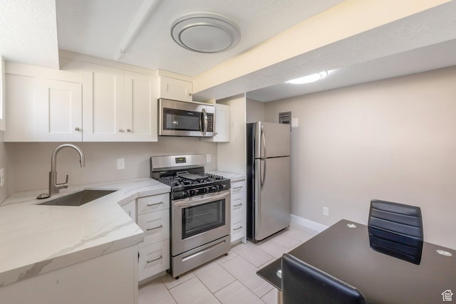 561 N 700 E, Provo, UT 84606 - kitchen featuring stainless steel appliances, a sink, white cabinets, light tile patterned flooring, and light stone countertops