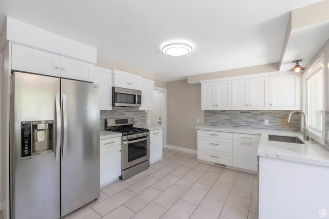 561 N 700 E, Provo, UT 84606 - kitchen featuring stainless steel appliances, backsplash, a sink, and white cabinets