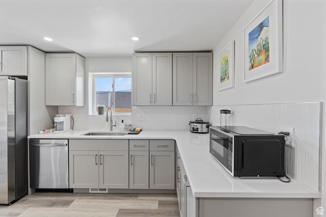 3649 S Hawkeye St, West Valley City, UT 84120 - kitchen featuring stainless steel appliances, a sink, gray cabinets, light countertops, and recessed lighting