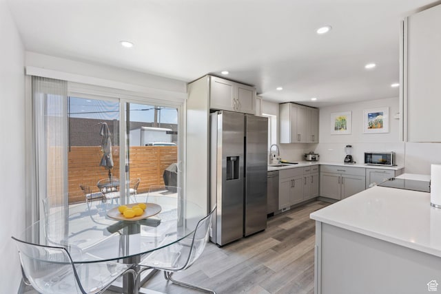 3649 S Hawkeye St, West Valley City, UT 84120 - kitchen with stainless steel appliances, gray cabinetry, a sink, light wood-style flooring, and recessed lighting