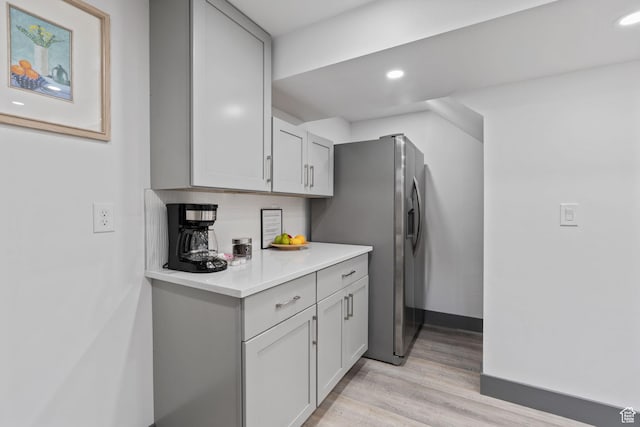 3649 S Hawkeye St, West Valley City, UT 84120 - kitchen with light countertops, stainless steel refrigerator with ice dispenser, light wood finished floors, recessed lighting, and gray cabinetry