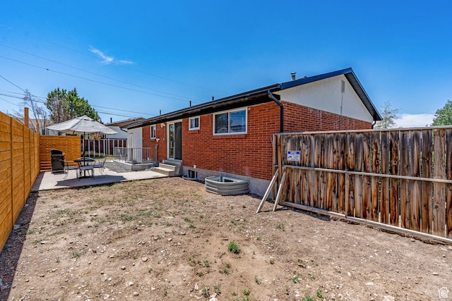 3649 S Hawkeye St, West Valley City, UT 84120 - rear view of property with brick siding, a patio area, and a fenced backyard