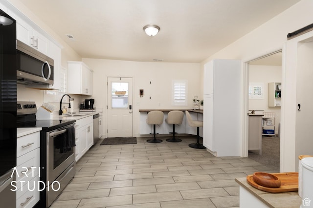 697 E Center St, Springville, UT 84663 - kitchen with stainless steel appliances, a sink, white cabinets, and light countertops